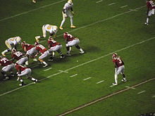 American football players in middle of a running play.