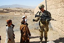 Australian soldier with a HK417 in Afghanistan. Australian Army Pvt. Levi Mooney, right, bumps fists with a child during a patrol in Tarin Kowt, Uruzgan province, Afghanistan, July 26, 2013 130726-Z-FS372-401.jpg