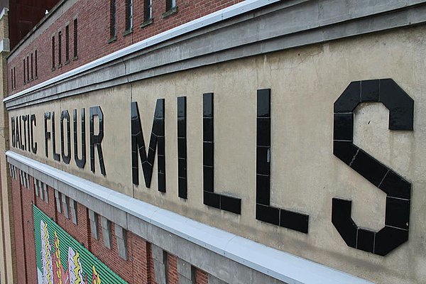 Side-view of the BALTIC FLOUR MILLS lettering. The preservation of the original lettering signifies the building's relationship to its history.