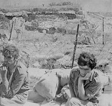 Fotografía que muestra a dos prisioneros israelíes en primer plano sentados, abatidos.