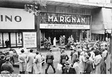 Em setembro de 1940, durante a ocupação alemã, o dignitário nazista Robert Ley na entrada da passagem Marignan da avenue des Champs-Élysées, durante uma visita aos serviços parisienses da organização Kraft durch Freude.  Um grande painel com o nome deste último e o do Deutsche Arbeitsfront de que depende, encima o acesso à passagem.