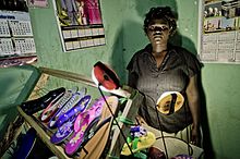 A shop owner in an off-grid area of Uganda using solar lighting solutions CleanStart Uganda photo.jpg