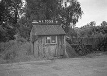 Local coal merchant in a station yard, Hook, Hampshire, England, 1965. Office at centre, coal stores on the right. Coal merchant at Hook Railway Station Hampshire (cropped).jpg