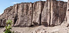 Fotografía de la entrada a la cueva en una escarpada pared rocosa