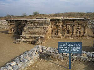 An English-Urdu bilingual sign at the archaeological site of Sirkap, near Taxila. The Urdu says: (right to left) dw srwN wly `qb khy shbyh wl mndr, do saron wale u'qab ki shabih wala mandir. "The temple with the image of the eagle with two heads." Double-Headed Eagle Stupa at Sirkap 06.jpg