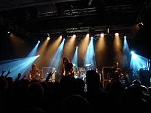 Gojira onstage, under blue and white lights