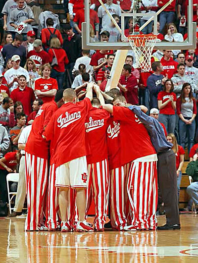 Basketball players huddle before a game in their iconic candy striped pants