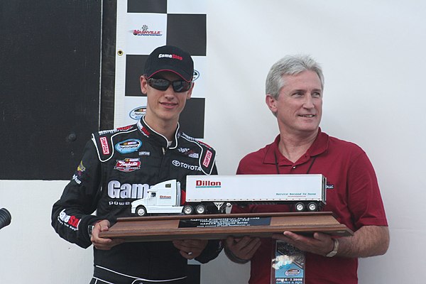Logano holds his trophy for winning the pole position in Nashville