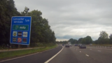 Signage for Lancaster Services, showing the distance, operator of the facility Moto and the brands such as BP and Burger King available at the stop.