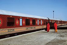 Maharajas' Express halted at a railway station in Rajasthan and two ladies wearing traditional rajasthani dress, passing by. Maharaja Express.jpg