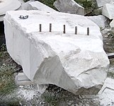 Splitting a block of marble with plug and feathers