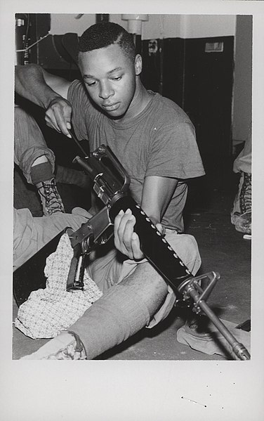 A Marine of the 3rd Battalion, 1st Marines cleans his XM16E1 in December 1967