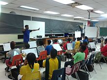 Roots of Music instructor Arden Jones directing a part of the brass section during practice in 2015 Rootsofmusic ardenjones brass001.jpg