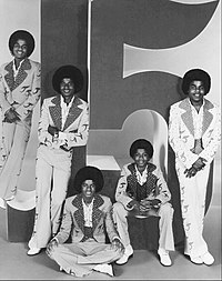 I Jacksons ritratti nel 1976 (da sinistra a destra: Marlon, Jackie, Michael, Randy e Tito) con ancora il logo J5 alle loro spalle, che in breve non avrebbero più potuto utilizzare per questioni di diritti.