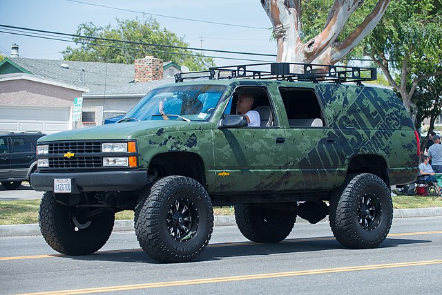 Chevrolet Suburban raised with aftermarket wheels and suspension mods – note much greater ground clearance under front with independent suspension, co