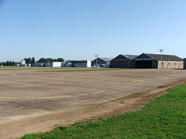 Buildings and a small plane, seen across a runway