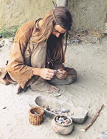 Costumed bronze-age re-enactor knapping stone tools.jpg