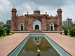 A Mughal-style fort in red stone and a pond in front