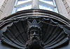 Stone-carved head of Neptune on the facade of a building