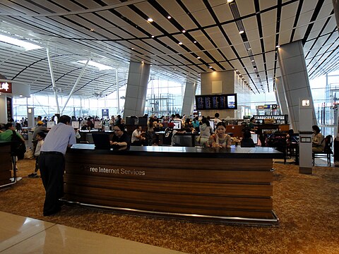 Interior view of Satellite Terminal, Hong Kong Airport. Central internet kiosk with coffee shop behind.