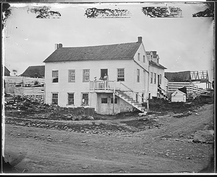 Burns' house shortly after the battle. Burns is seated at top of stairs.