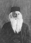 Retrato fotográfico de Julien Chassevant, envelhecido e com um cordão de barba branca.