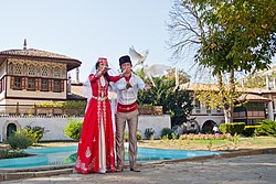 Кримски татари в традиционни дрехи на фона на Бахчисарайският дворец