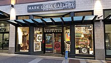 Mark Loria Gallery storefront on Fort Street in Victoria, BC. Double glass doors are flanked by floor-to-ceiling windows through which can be seen art pieces.