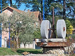 Sur le rond-point à l'entrée nord de la ville, des meules de moulin à huile d'olive.