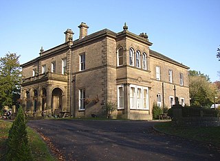 A stone house in two storeys, with an entrance portico and a two-storey bay window