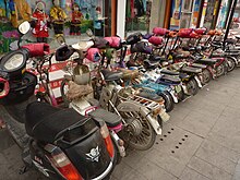 The Chinese version of hand-protecting "pogies", used on electric bicycles in cold weather. Qufu - electric bikes parked - P1060310.JPG