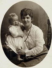 Молодая шатенка с младенцем на руках.