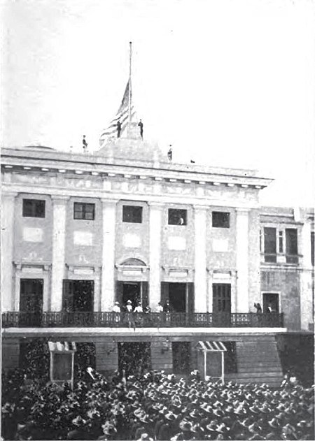 A public spectacle occurs as the flag of the United States is raised over San Juan on October 18, 1898..