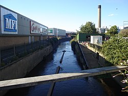 Salmons Brook at the Eley Industrial Estate before flowing under North Circular Road at Angel Road, Edmonton. The Edmonton Incinerator is in the background