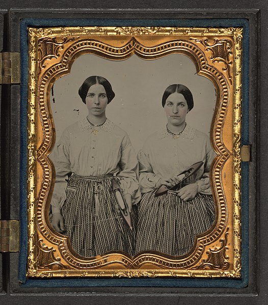 File:Sisters Lucretia Electa and Louisa Ellen Crossett in identical skirts, blouses, and jewelry with weaving shuttles LCCN2010648856.jpg