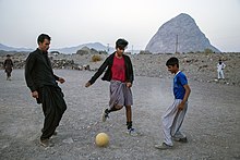 مردان بلوچ با لباس محلی در حال بازی فوتبال