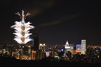 Taipei 101 New Year fireworks in 2016, with Taipei Nan Shan Plaza on the side, nearing completion