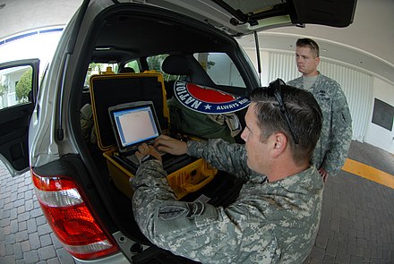 A Florida Army National Guardsman uses a Single Mobile User Case Set to send a situation report on ongoing preparations for Hurricane Ike in Key West, Florida.