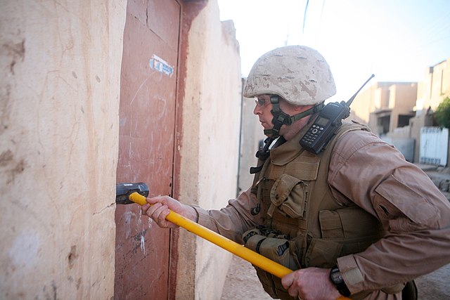 A Marine with Battery M, 3/14 hammers a door during a cache search in Rutbah, Iraq.