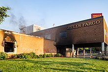 A smoldering Wells Fargo bank building on Nicollet Avenue in Minneapolis, May 29, 2020. Wells Fargo Bank on Fire - Minneapolis Protests (50782673218).jpg