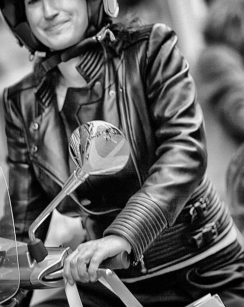 Woman in leather jacket on a Vespa scooter in Belgium