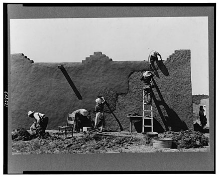 Renewal of the surface coating of an adobe wall in Chamisal, New Mexico