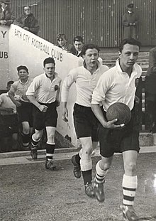 Bath players entering from the Grandstand of Twerton Park before a match in the 1930s. Bath City players in the 1930s.jpg