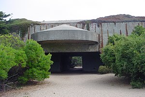 Recent photo of an emplacement of Battery Davis. Some of the earth covering the fort has eroded. BatteryDavis Gun1.jpg