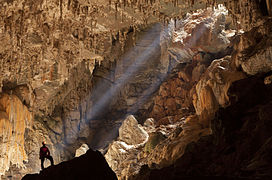 Speleologist observing sun rays inside the Terra Ronca cave