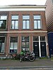 Beneden- en bovenwoning in blokje van twee benedenwoningen en twee bovenwoningen uit het laatste kwart van de 19de eeuw in sobere classicistische vormen. De woningen zijn van belang als deel van het blokje Bagijnhof 5/5a-7/7a. Het is een relatief gaaf voorbeeld van laat-19de-eeuwse woningbouw in de oude binnenstad. Een toegevoegde waarde wordt gevormd door de ligging aan het Bagijnhof en de bijdrage aan de herkenbaarheid van dat plein.