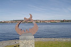 Статуята на езерното чудовище на фона на езерото Стуршьон