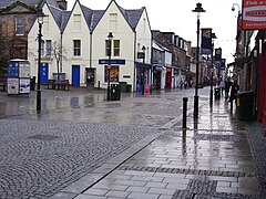 Rainy, cobbled street with low buildings