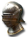 Late example of a German visored sallet (transitional to the close helm), c. 1495. The bevor and the brow-reinforce attach to the same pivot as the upper visor, and the tail at the rear of the helmet is much shorter than in earlier forms.