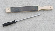 A leather strop on a wooden handle, top. The leather is coated with green chromium oxide polishing compound. Bottom, one pattern of butcher's steel for knife edge maintenance. Household knife maintenance tools.jpg